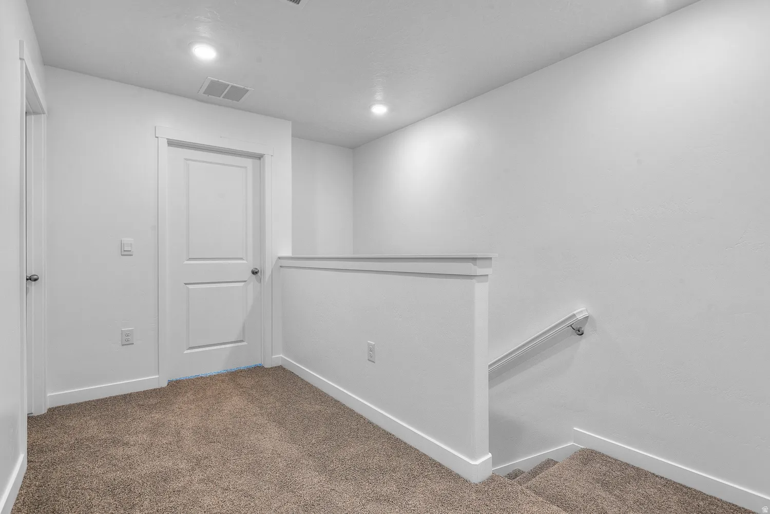 Corridor with an upstairs landing, carpet, and recessed lighting
