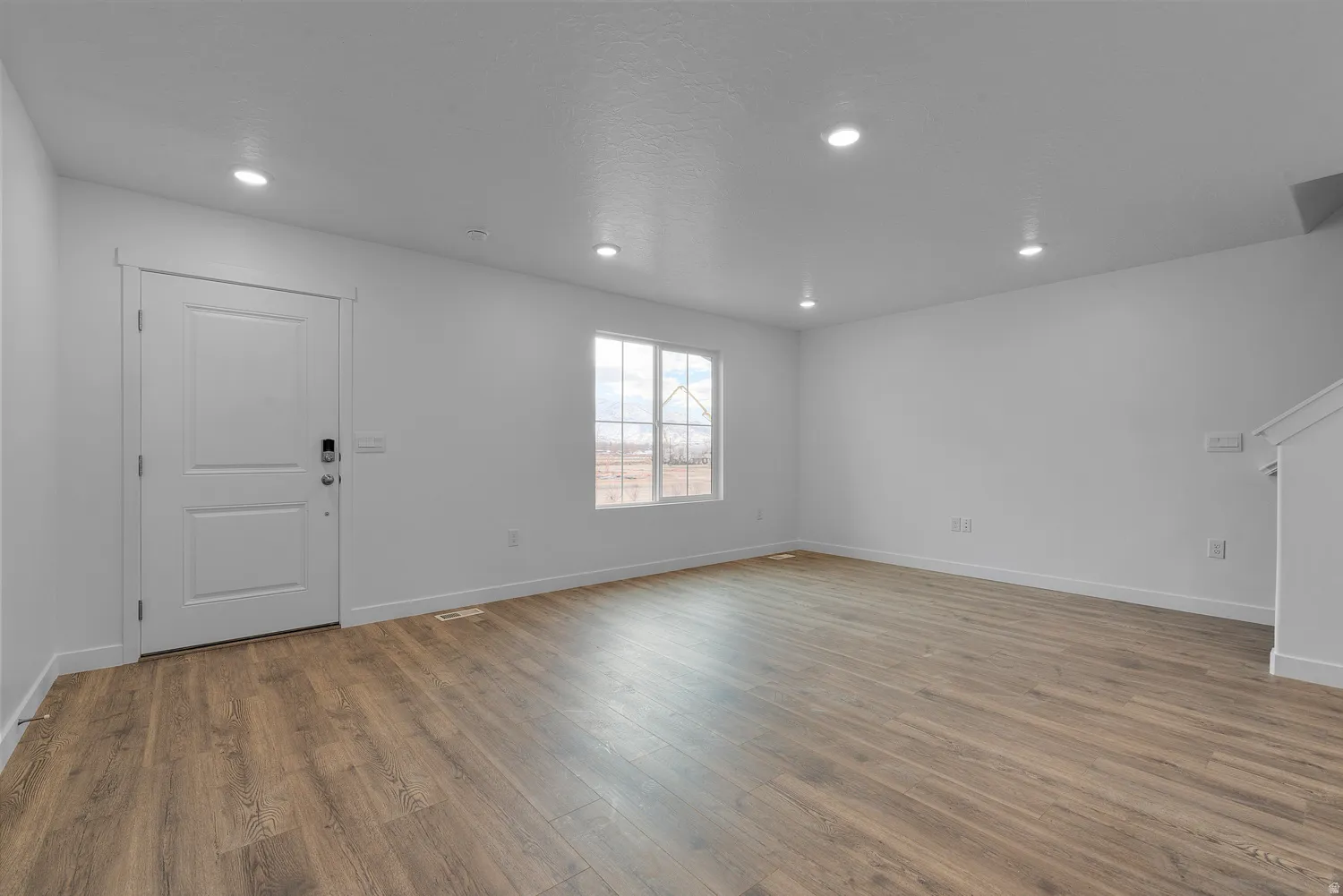Unfurnished living room featuring light wood finished floors and recessed lighting