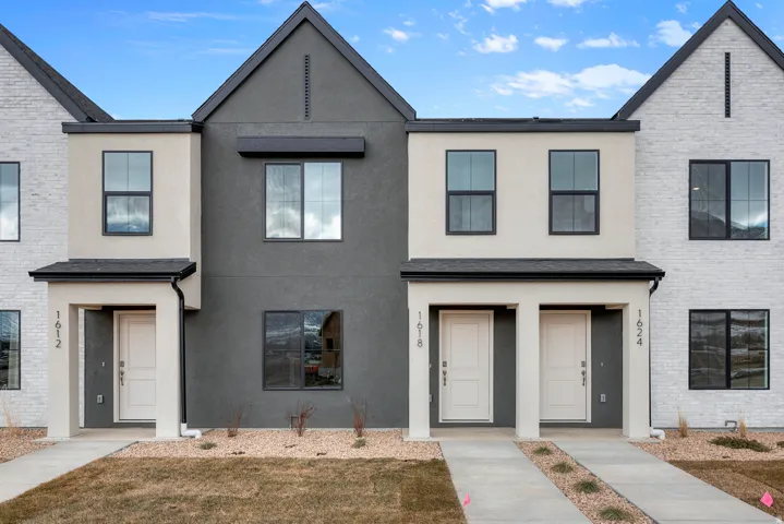 View of front of house with stucco siding and a front yard