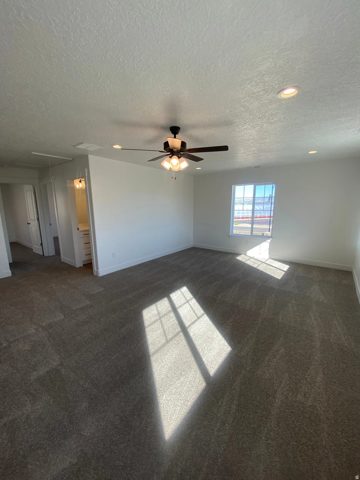 Empty room with dark colored carpet, ceiling fan, recessed lighting, and a textured ceiling*Photos are for reference only and are not of specific unit listed.  Finishes may differ from pictures shown.