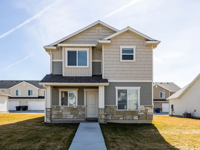 Craftsman inspired home with board and batten siding, stone siding, and a front lawn
