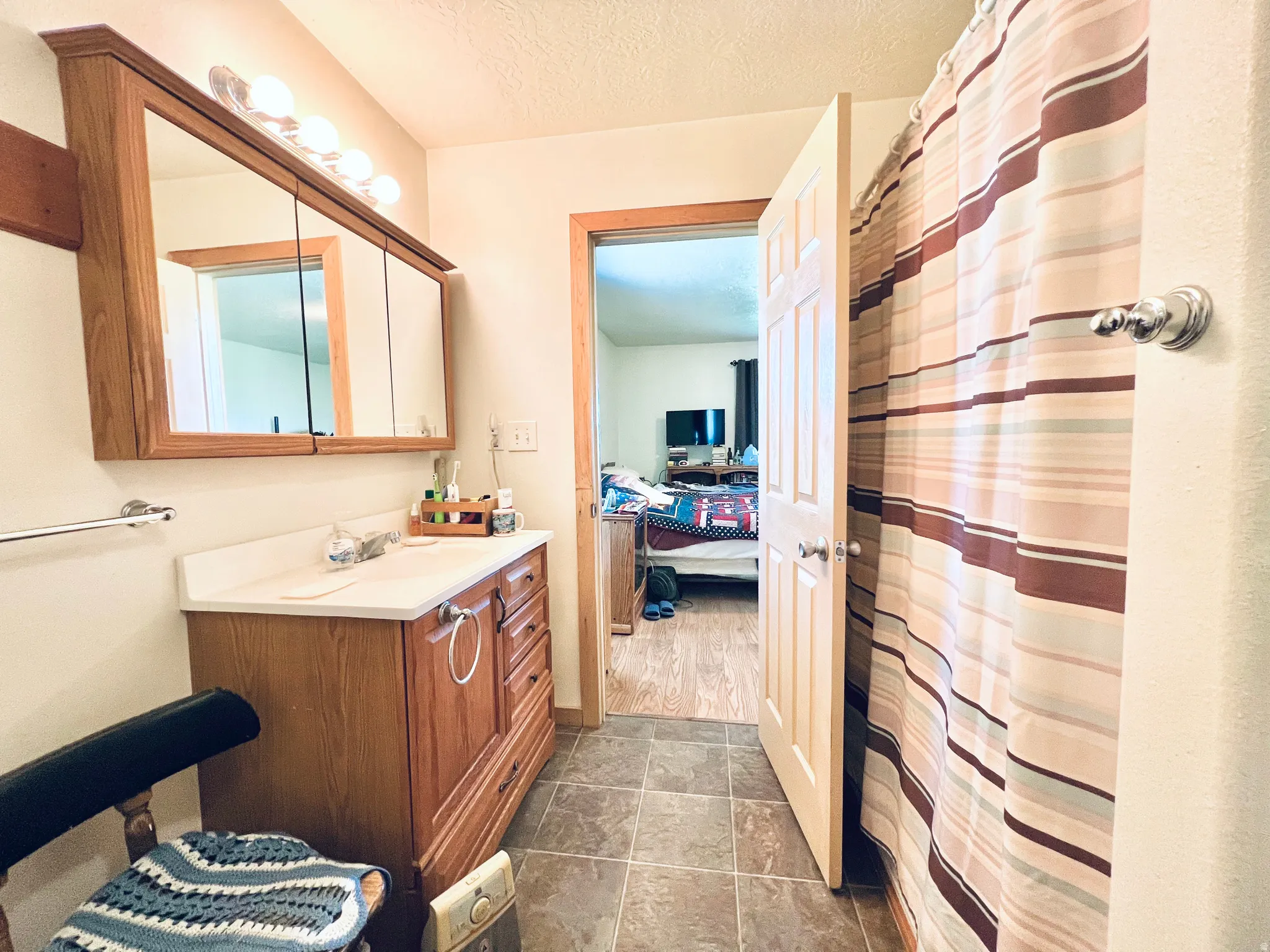 Full bathroom featuring vanity, a textured ceiling, a shower with curtain, and ensuite bathroom