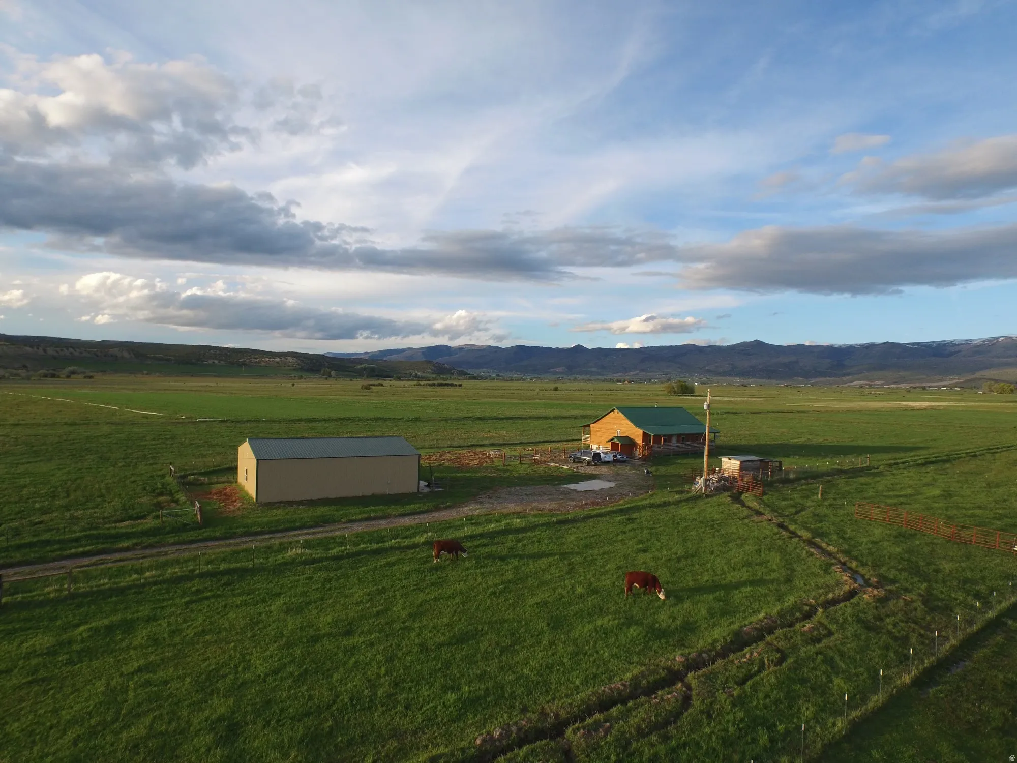 View of community featuring a view of countryside, a mountain view, a pole building, and a storage shed