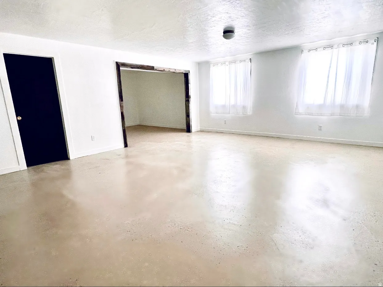 Empty room featuring a textured ceiling and finished concrete floors
