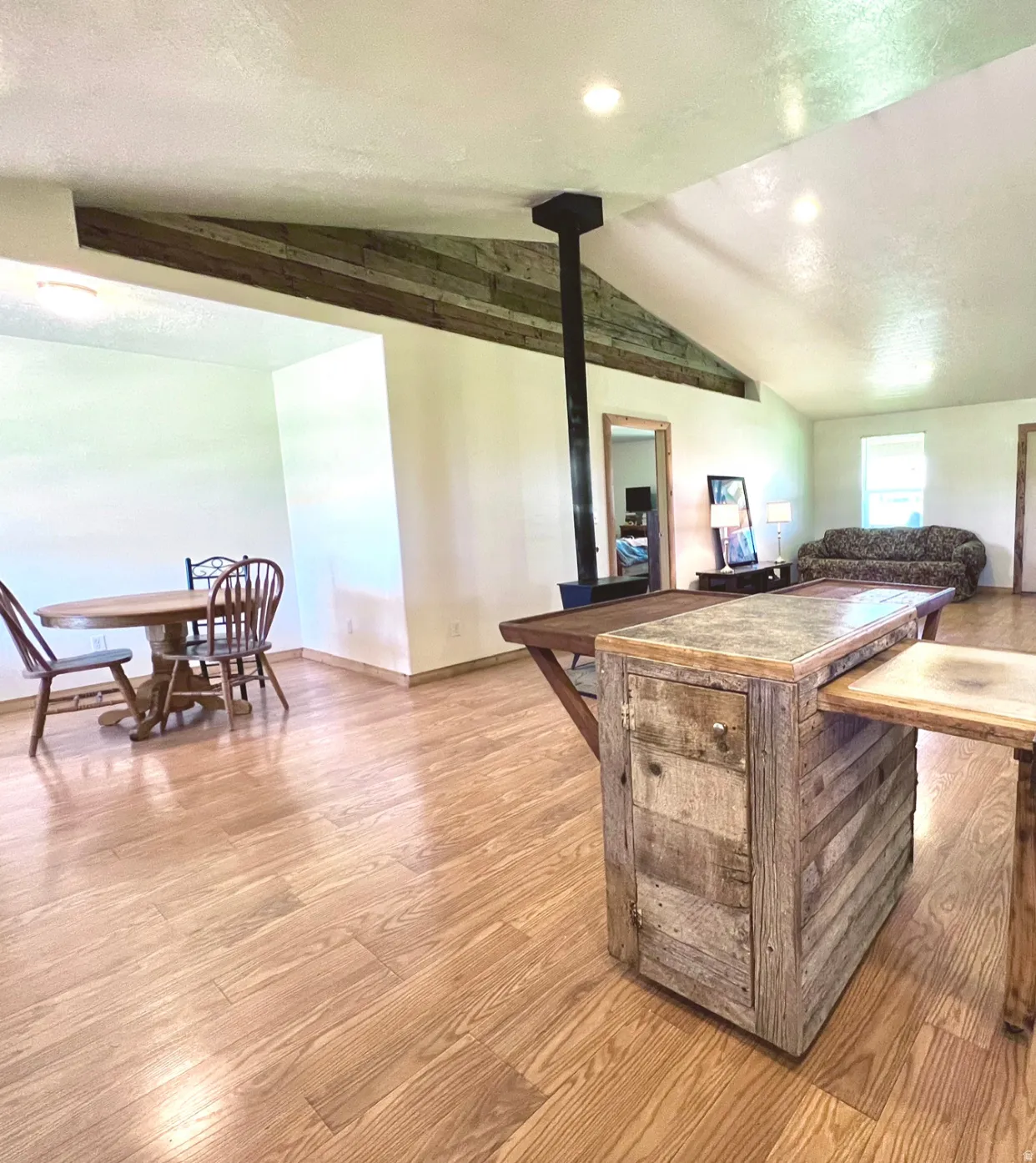Kitchen with wood finished floors, a wood stove, and a textured ceiling