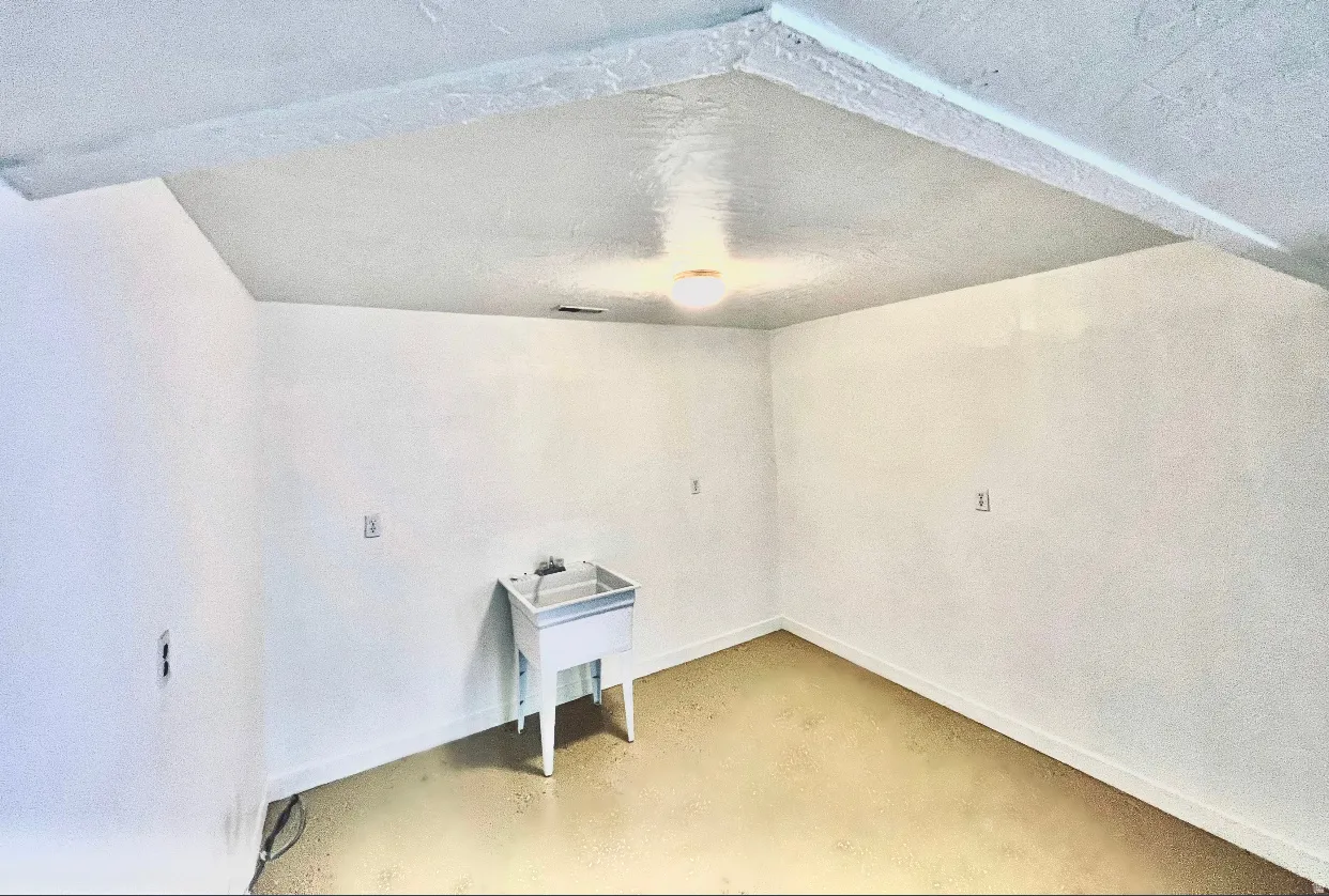 Unfurnished room with concrete flooring and a textured ceiling