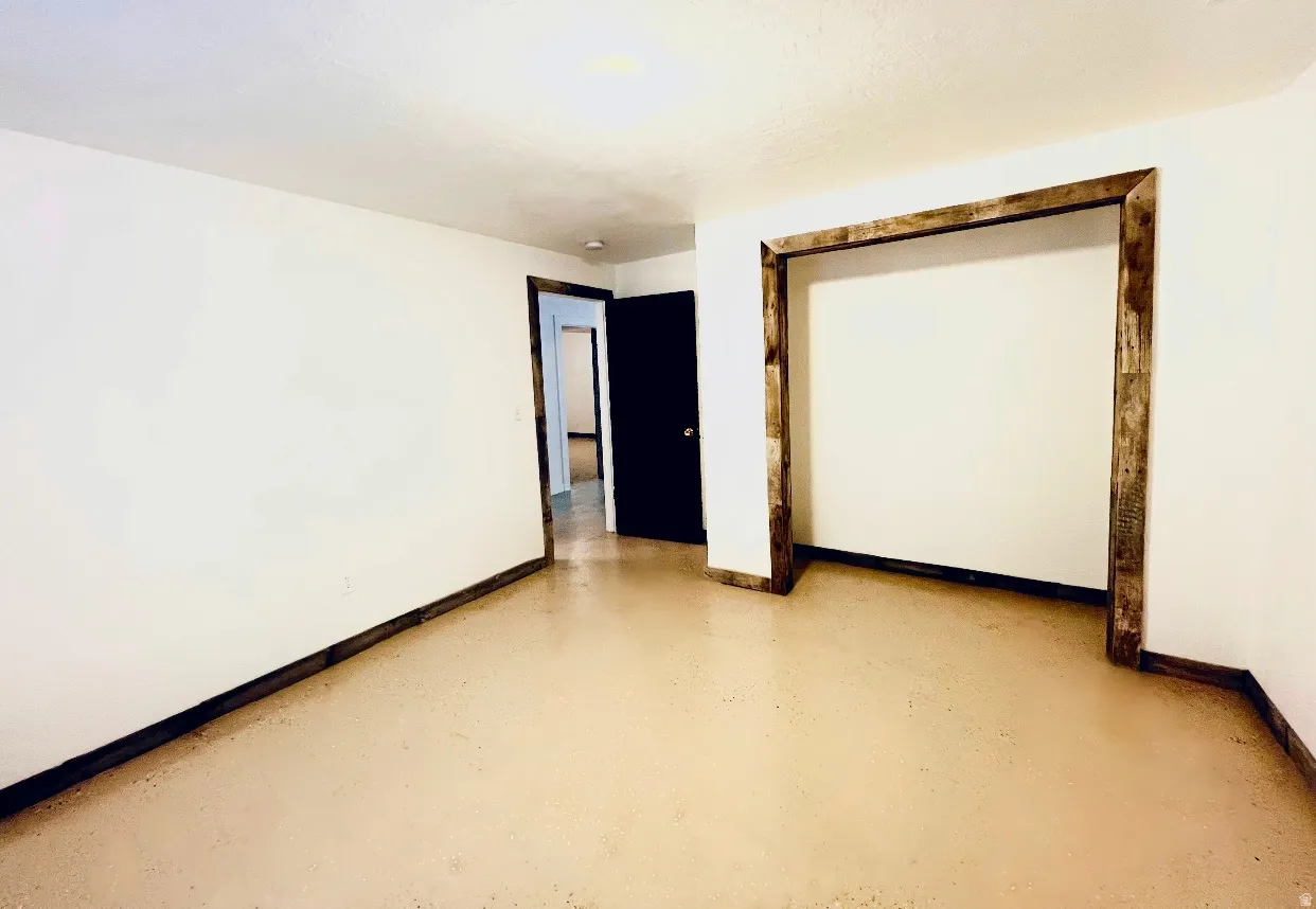 Spare room with baseboards and finished concrete flooring