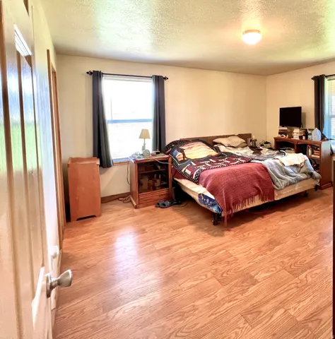Bedroom featuring light wood-style floors and a textured ceiling