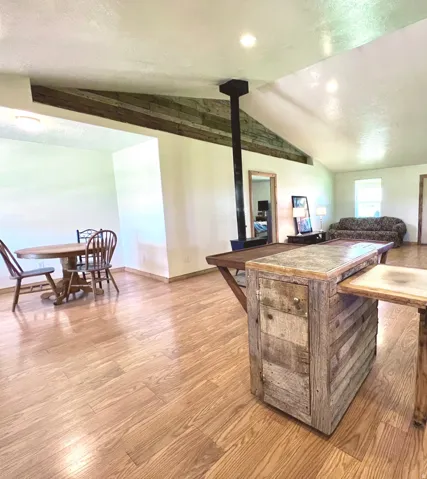 Kitchen with wood finished floors, a wood stove, and a textured ceiling