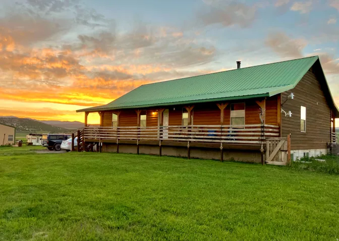 Back of property at dusk featuring a mountain view, a metal roof, and a porch