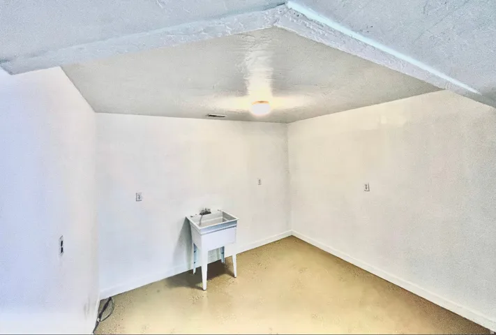 Unfurnished room with concrete flooring and a textured ceiling