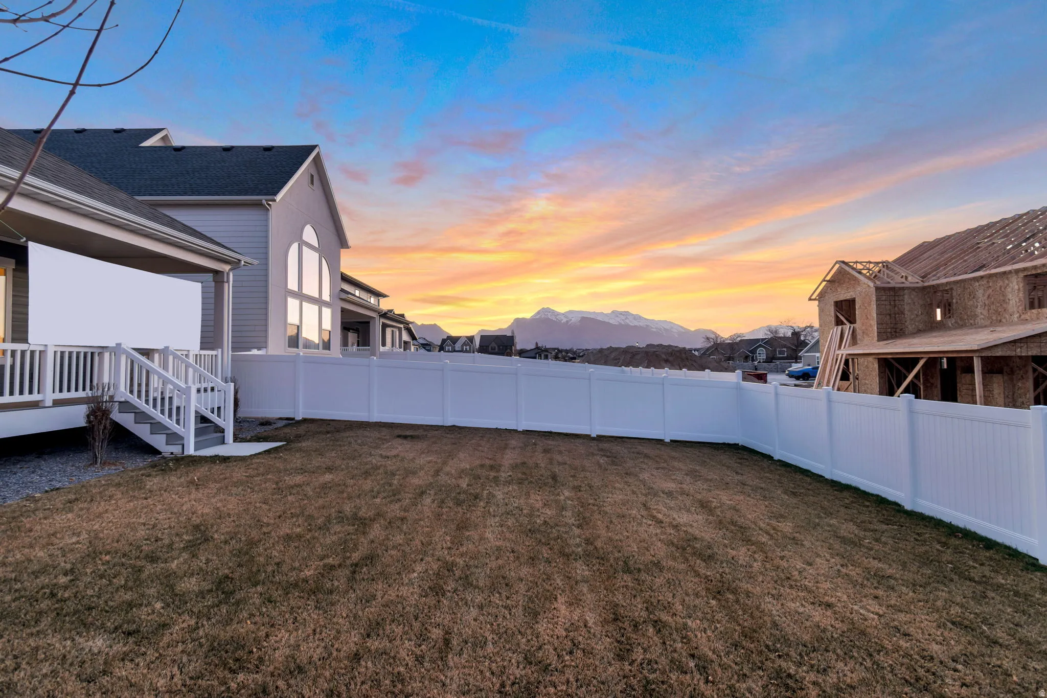 Yard at dusk featuring a fenced backyard and a mountain view