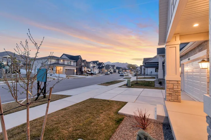 View of asphalt road featuring sidewalks, a residential view, and curbs