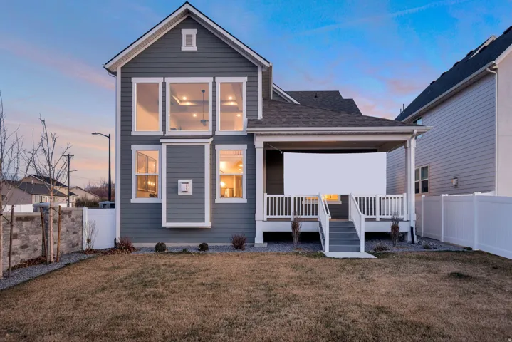 Rear view of property with a fenced backyard, a shingled roof, and covered porch