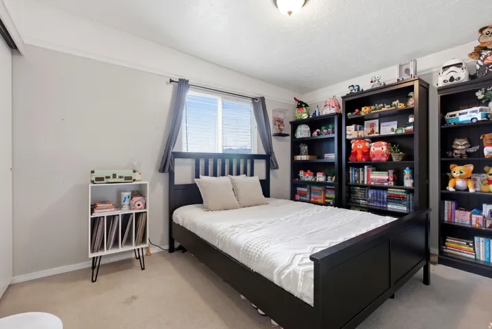 Bedroom with light carpet and a textured ceiling