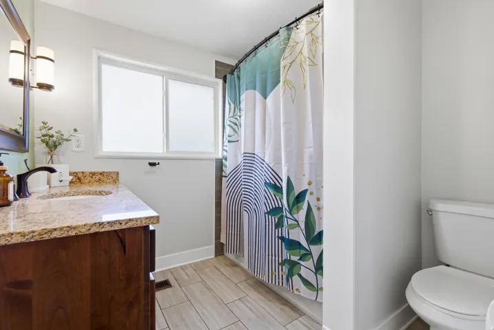 Full bath with vanity, a shower with curtain, and wood tiled floors