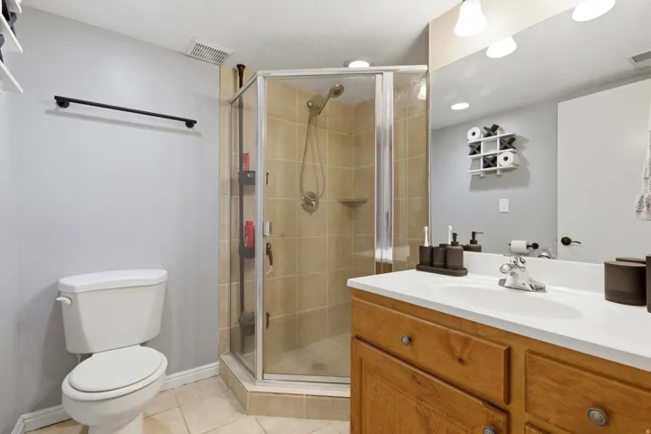 Bathroom featuring vanity, a stall shower, and light tile patterned flooring