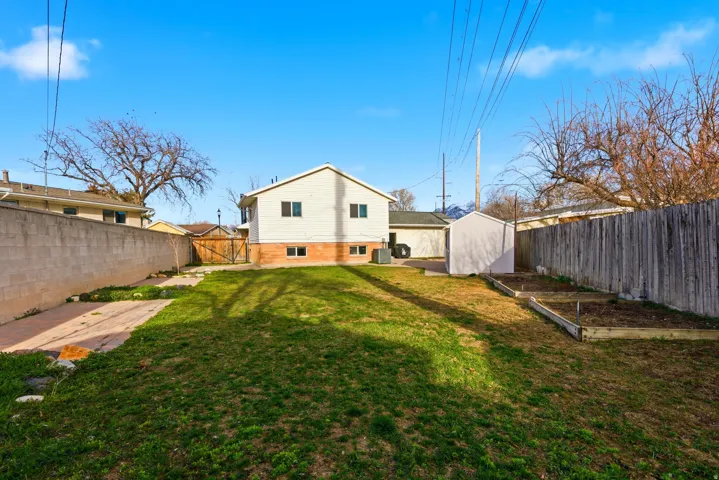 Back of property with a fenced backyard, a gate, and a patio