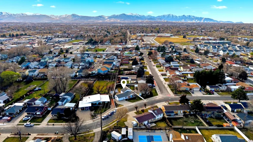 Aerial view of property's location with a mountainous background and nearby suburban area