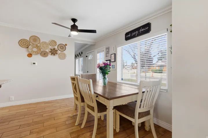 Dining space featuring light wood finished floors, ornamental molding, and ceiling fan