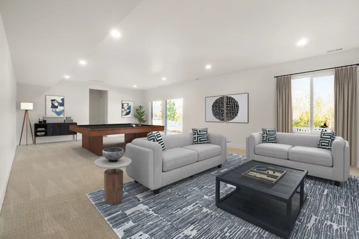 Spacious entertainment area featuring recessed lighting, light-toned carpeting, and a built-in sliding glass door