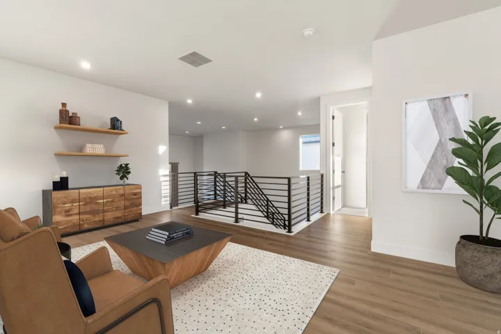 Contemporary interior featuring light wood-finish flooring, recessed lighting, and a modern stair railing with black metal balusters