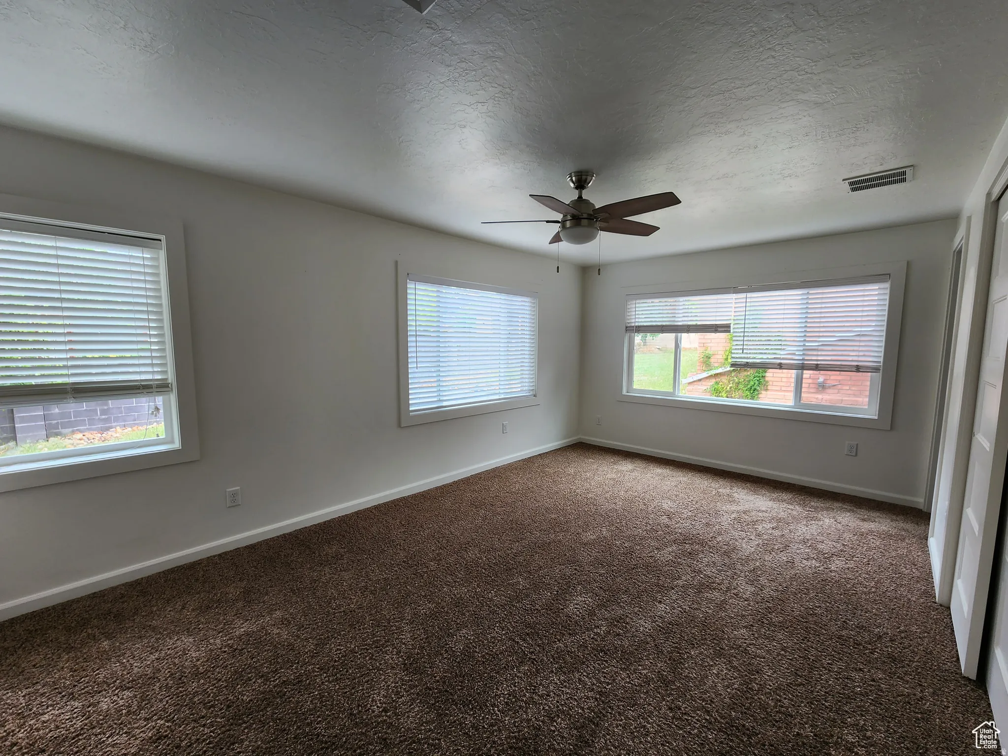 #1 Primary Suite featuring lots of sun-light, carpet, ceiling fan, custom closet and access to private bathroom