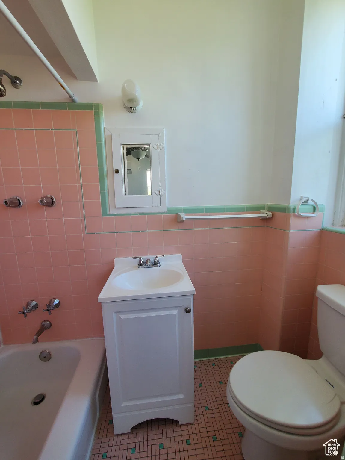Bathroom featuring vanity, shower / bathtub combination, custom vintage tile walls
