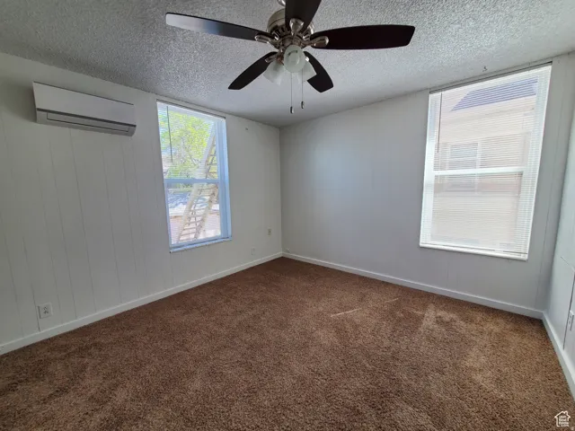 Studio with a ceiling fan, painted wooden walls, and mini-split A/C & Heating unit
