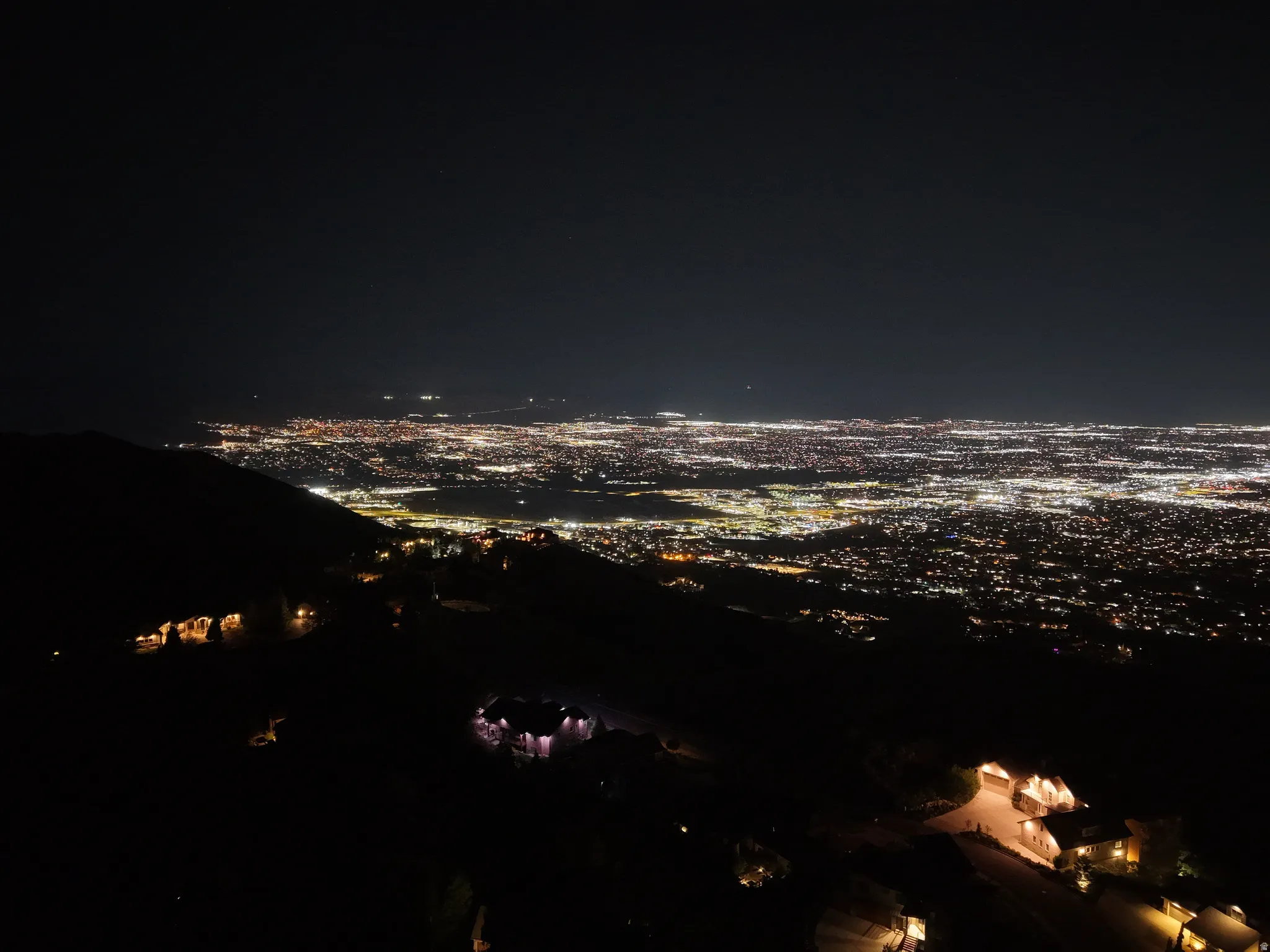 Expansive cityscape stretching across the horizon, featuring numerous illuminated buildings and streets