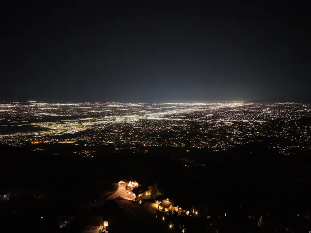 Expansive city lights panorama with illuminated residential structures at the foreground