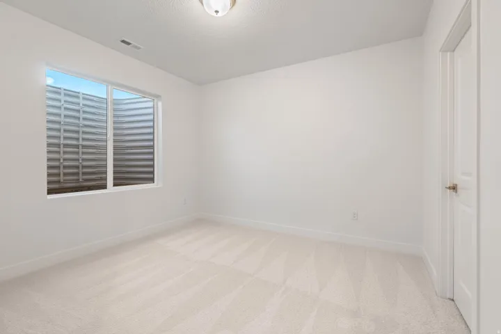 Spare room featuring light carpet and a textured ceiling