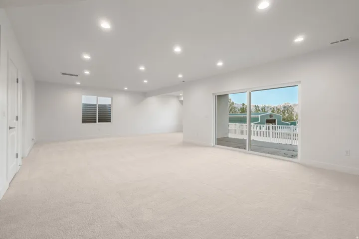Empty room featuring recessed lighting and light colored carpet