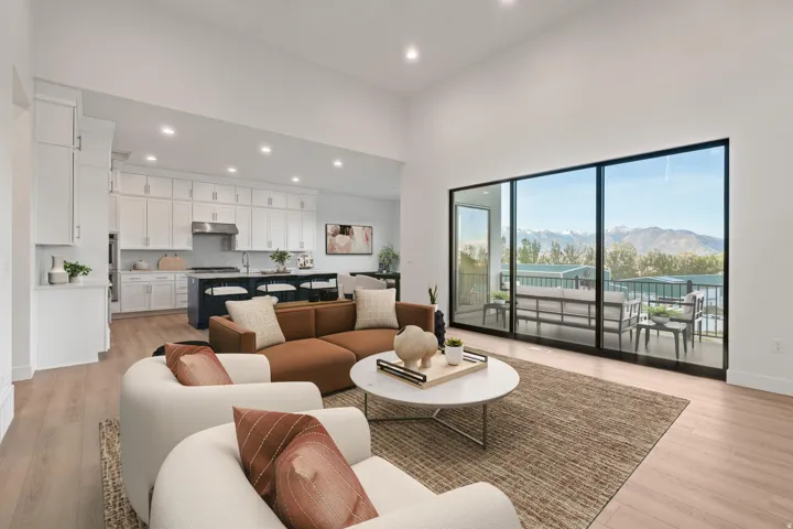 Open concept living area featuring wood-finish flooring, high ceilings, and recessed lighting