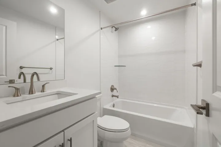 Bathroom with vanity,  shower combination, and recessed lighting