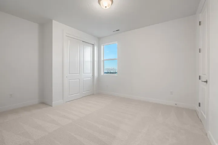 Unfurnished bedroom with light carpet and a closet