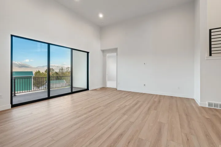 Unfurnished room featuring a mountain view, light wood-type flooring, a high ceiling, and recessed lighting
