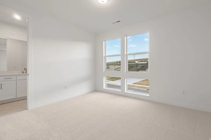 Empty room with light carpet and baseboards
