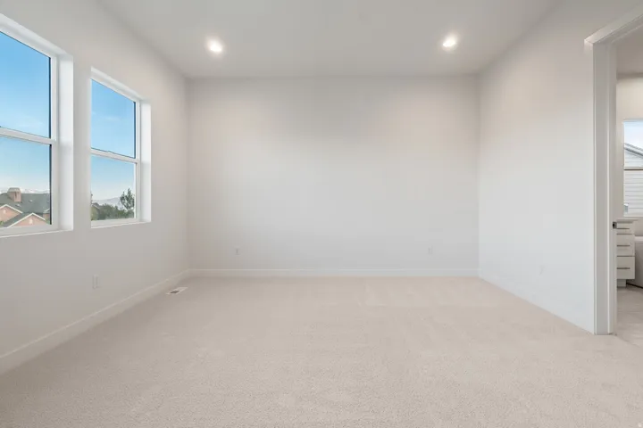 Empty room featuring light colored carpet and recessed lighting