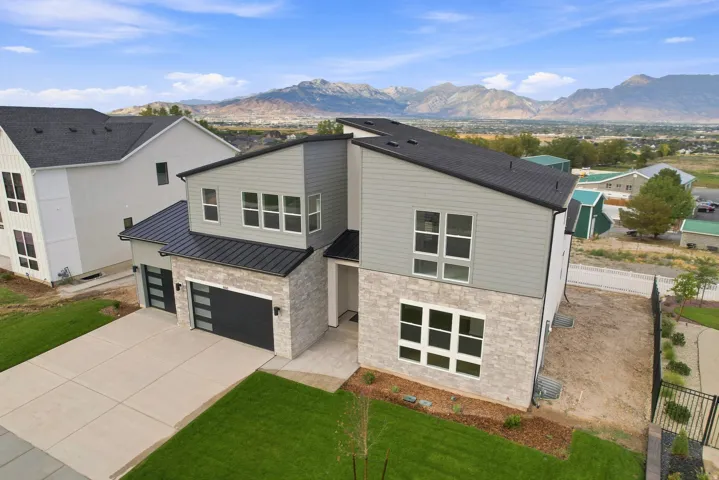 Modern-style exterior featuring a multi-tone facade, stone accents, and a dual garage