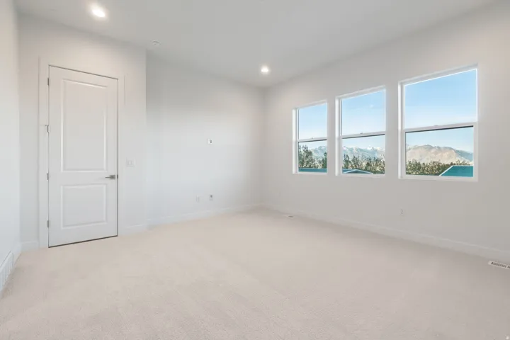 Empty room with light carpet, a mountain view, and recessed lighting