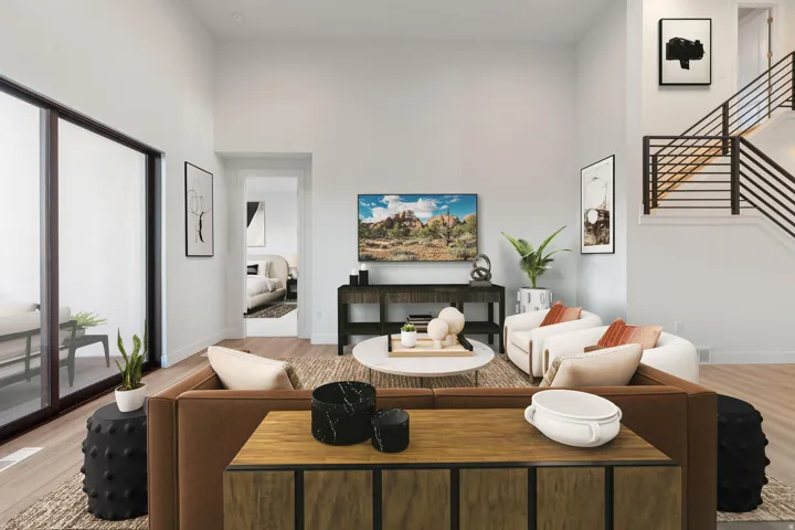 Spacious living area featuring wood-finish flooring, high ceilings, large sliding glass doors, and a modern staircase with horizontal railings