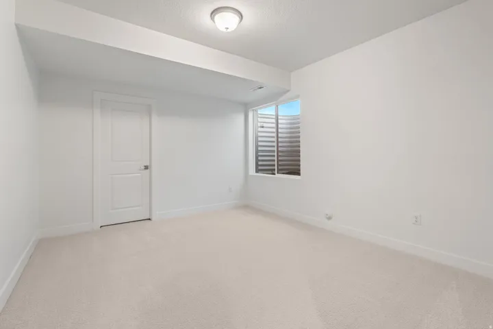 Spare room with light colored carpet and a textured ceiling