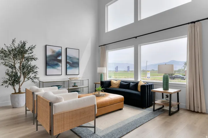 Vaulted ceiling with transom windows, large windows with mountain scenery, wood-finish flooring, and light wall finishes