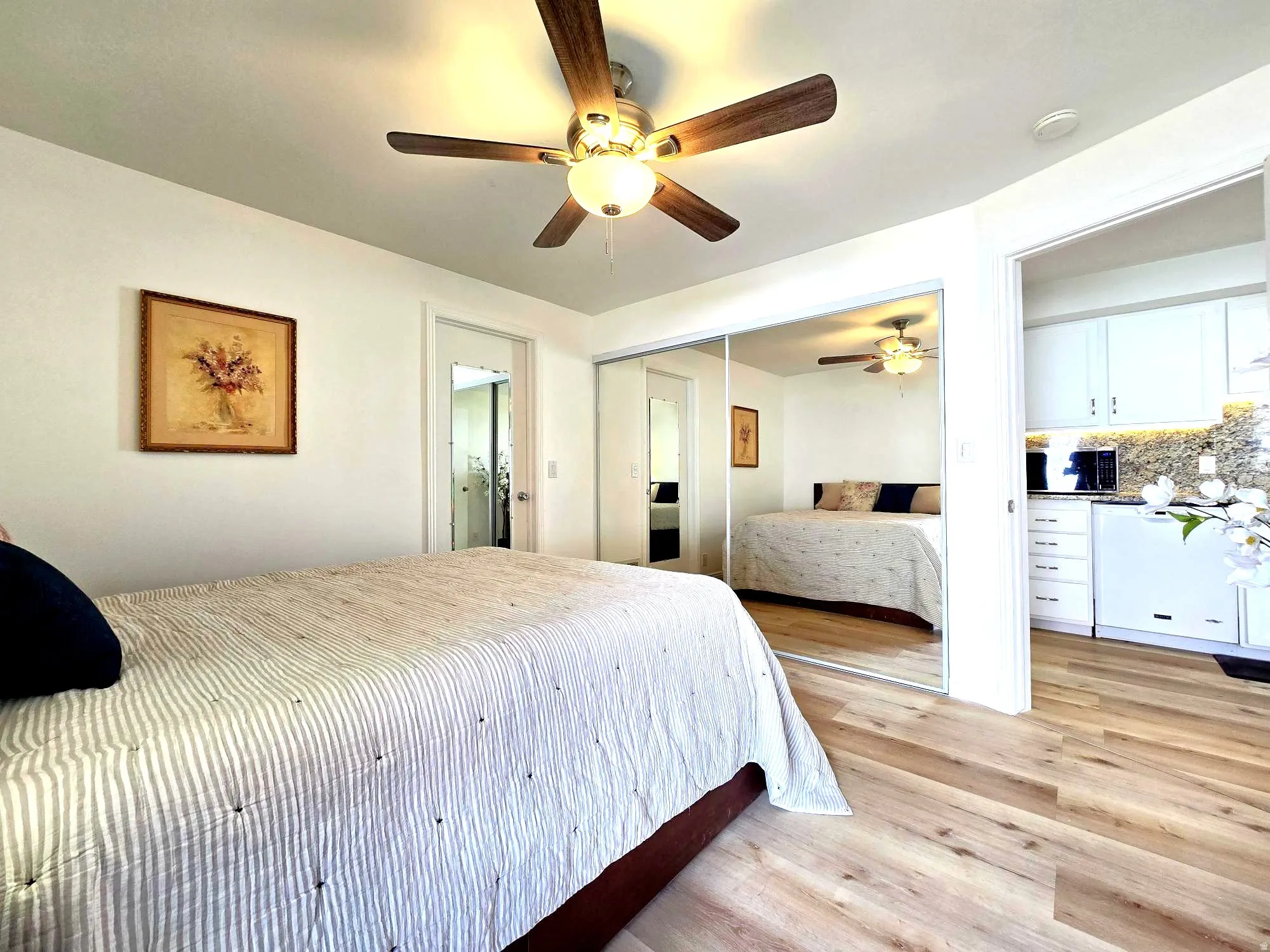 Bedroom featuring light wood-type flooring, a closet, and a ceiling fan