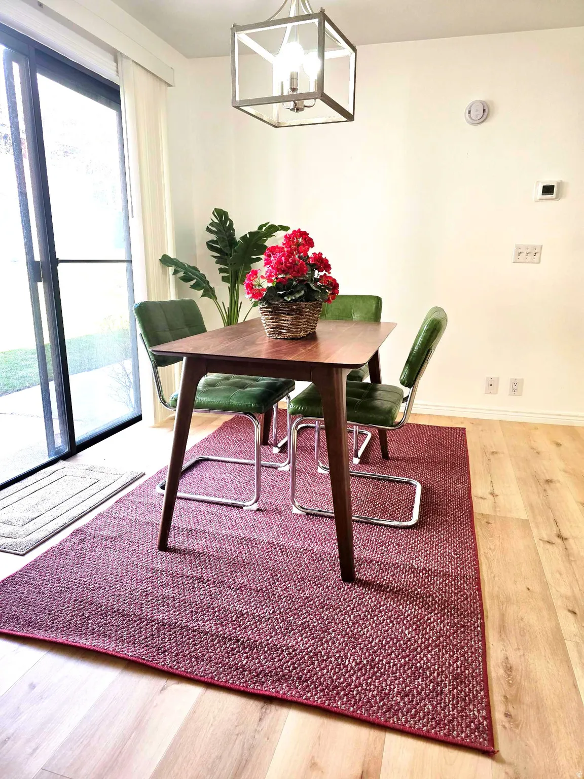 Dining space with light wood-style floors and hanging lights