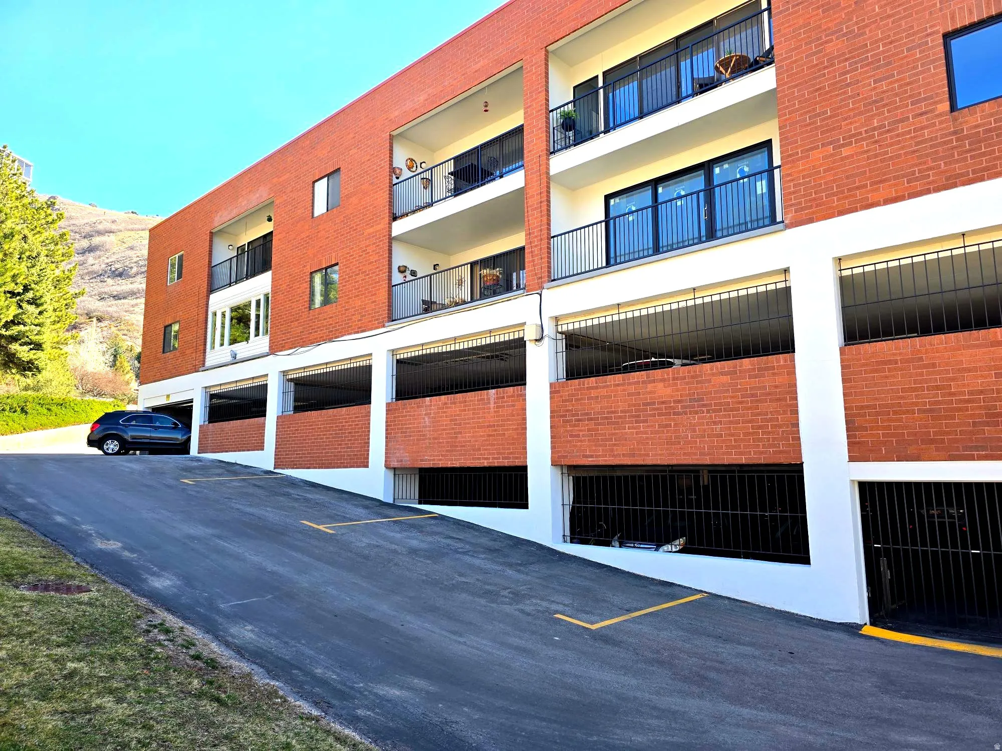 View of building / complex featuring garage and uncovered parking