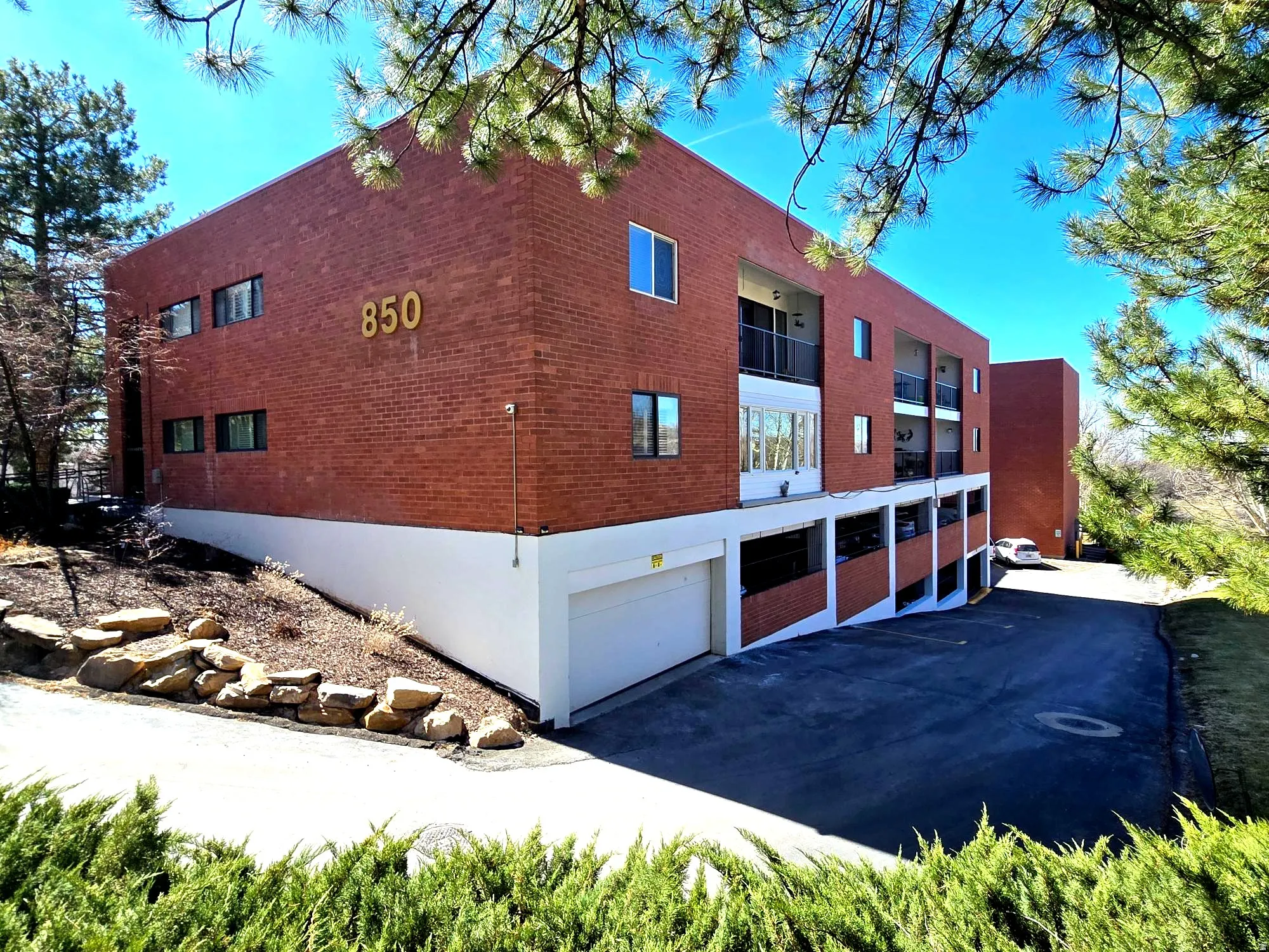 View of side of property featuring an attached garage and brick siding