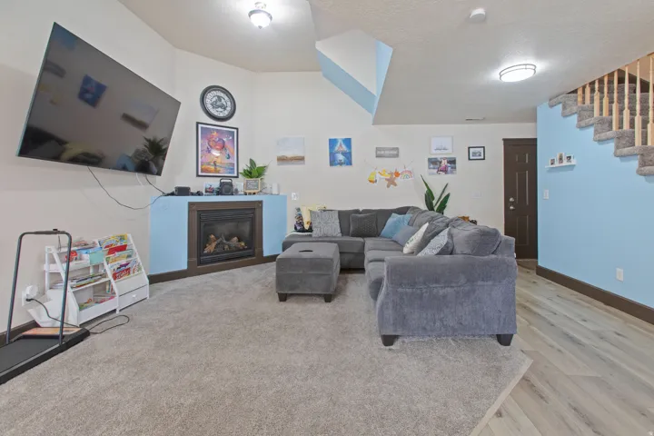 Living room with a glass covered fireplace, a textured ceiling, and light wood finished floors