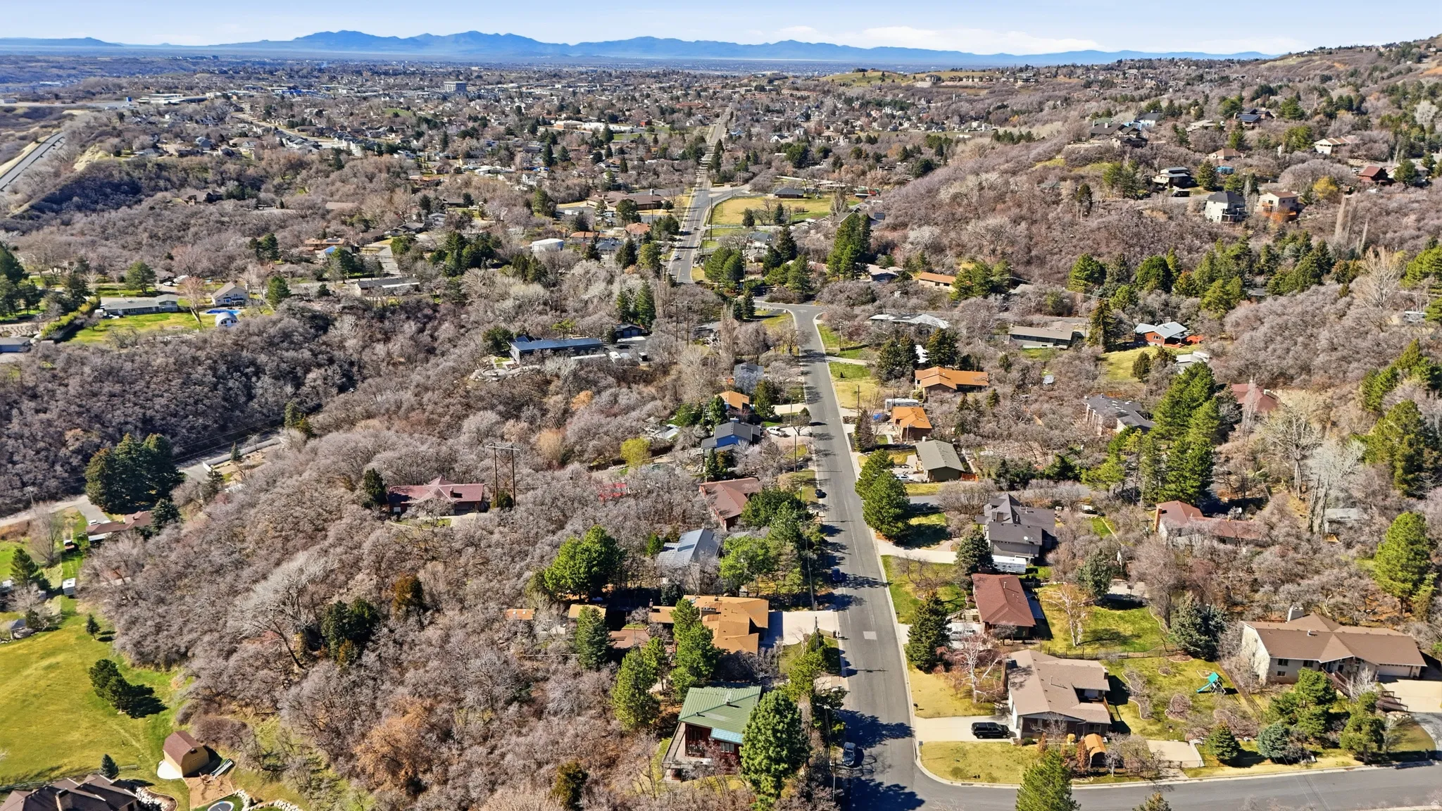 Aerial overview of property's location featuring mountains and nearby suburban area